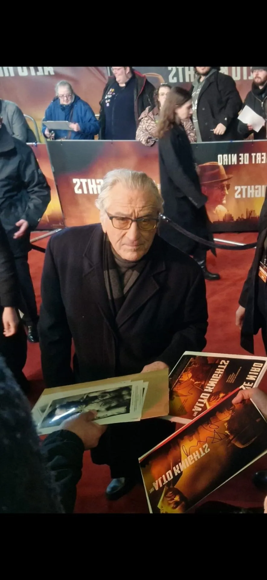 Robert De Niro signing movie posters at a premiere
